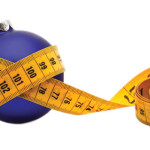 Tape measure around a bauble concept symbolizing Christmas weight gain from eating too much food.