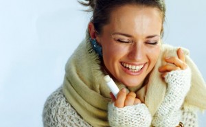 happy stylish middle age woman with lip balm as winter lip care