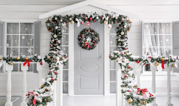 Christmas morning. porch a small house with a decorated door with a Christmas wreath. Winter fairy tale.