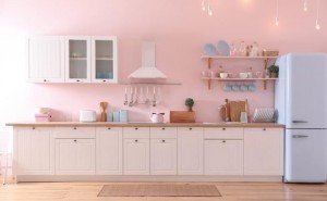 Stylish pink kitchen interior with modern furniture and fridge