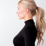 Eine blonde, junge, schöne Frau im Profil mit Pferdeschwanz