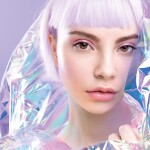 Cool sensual young blond girl with ideal brows, purple hair and perfect makeup, healthy glowing skin in colourful iridescent foil