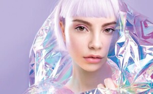 Cool sensual young blond girl with ideal brows, purple hair and perfect makeup, healthy glowing skin in colourful iridescent foil