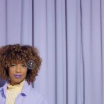 Mixed race black woman with curly hair and glow makeup